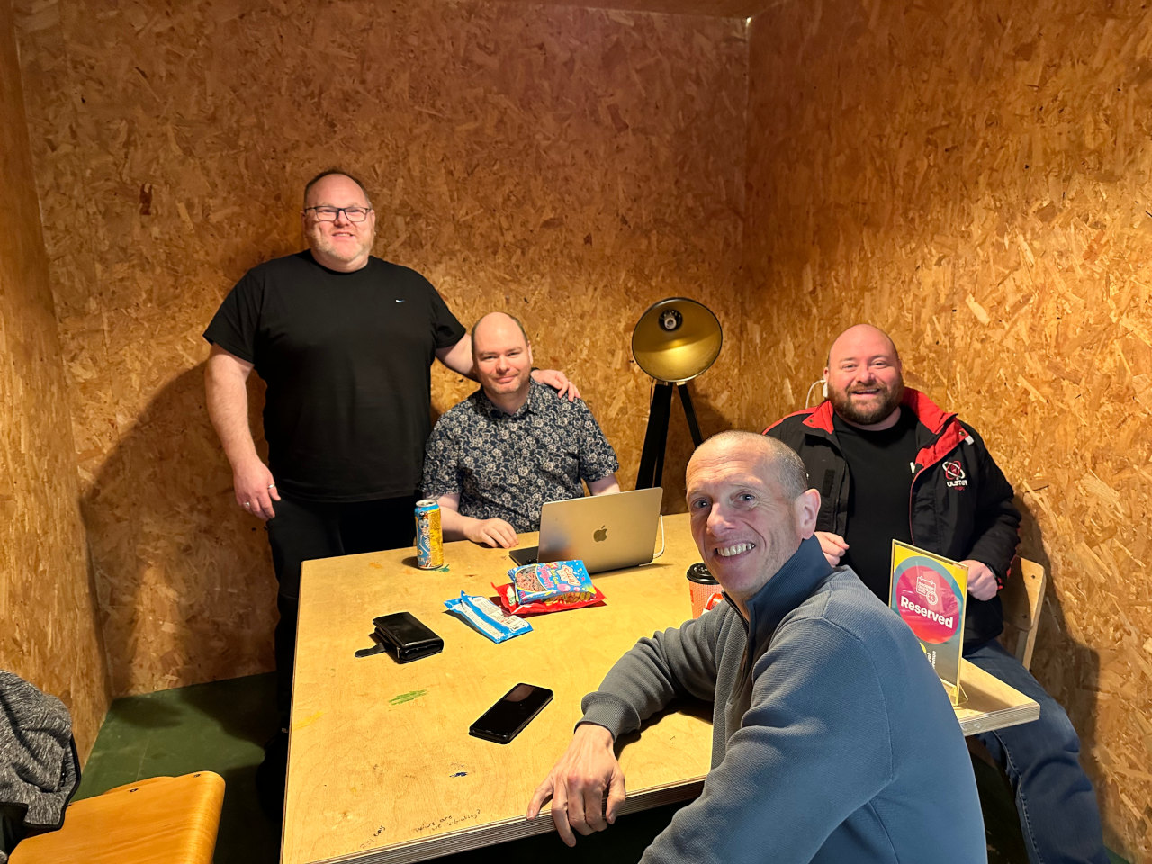 Members of The Mens Group smiling together around a table